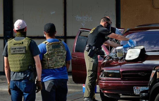 August 29, 2020, Albuquerque, NM, USA: BCSO officers record all the evidence of guns, cash and drugs on the hood of a vehicle they stoped at Pennsylvania and Central NE. Saturday, Aug. 29, 2020. Albuquerque USA - ZUMAab1_ 20200829_zaf_ab1_001 Copyright: xJimxThompsonx
