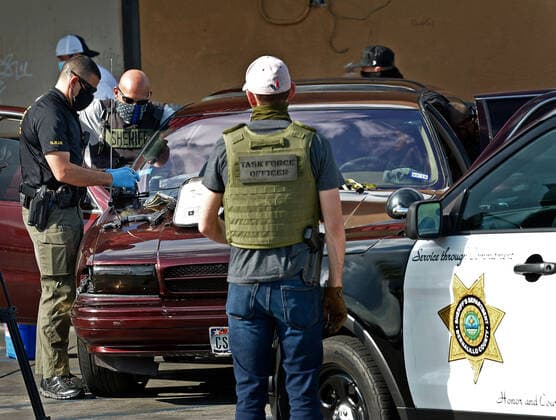 August 29, 2020, Albuquerque, NM, USA: BCSO officers record all the evidence of guns, cash and drugs on the hood of a vehicle they stoped at Pennsylvania and Central NE. Saturday, Aug. 29, 2020. Albuquerque USA - ZUMAab1_ 20200829_zaf_ab1_002 Copyright: xJimxThompsonx