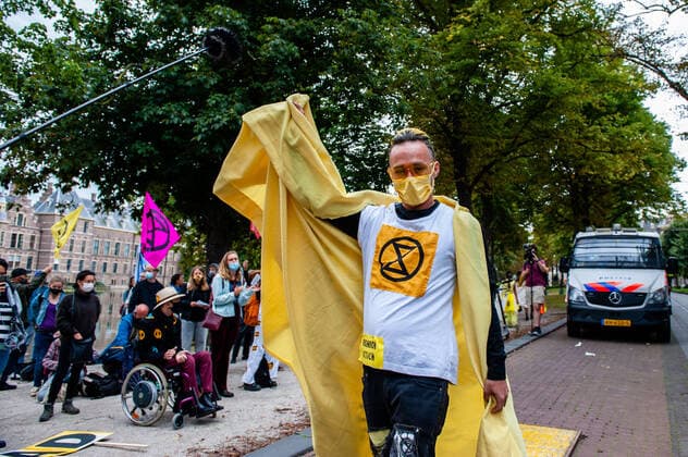 September 1, 2020, The Hague, South Holland, Netherlands: An XR model walking past a police van during the fashion show..An XR fashion show was carried out in front of the House of Representatives in The Hague. Models wore yellow, black, and white colourful second-hand outfits to symbolise the collectivity of bees, to show that thinking and working together can help us out of this crisis. The Hague Netherlands - ZUMAs197 20200901_zaa_s197_020 Copyright: xAnaxFernandezx