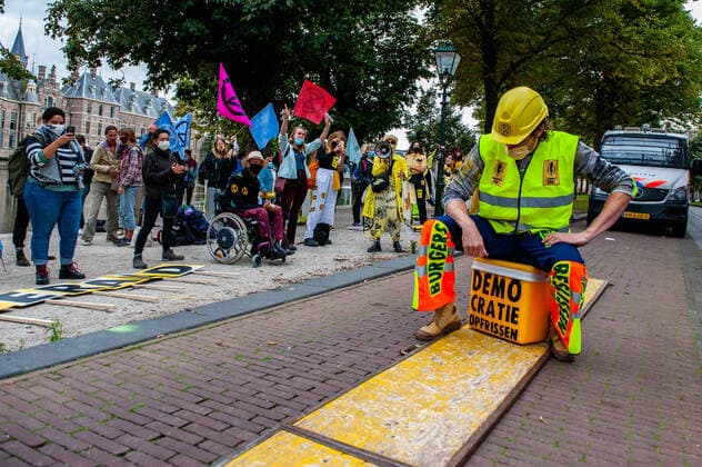 September 1, 2020, The Hague, South Holland, Netherlands: An XR model sitting over a portable cooler with an activist message during the fashion show..An XR fashion show was carried out in front of the House of Representatives in The Hague. Models wore yellow, black, and white colourful second-hand outfits to symbolise the collectivity of bees, to show that thinking and working together can help us out of this crisis. The Hague Netherlands - ZUMAs197 20200901_zaa_s197_021 Copyright: xAnaxFernandezx