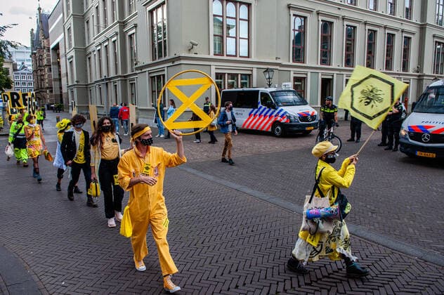 September 1, 2020, The Hague, South Holland, Netherlands: A group of XR models walking past police during the fashion show..An XR fashion show was carried out in front of the House of Representatives in The Hague. Models wore yellow, black, and white colourful second-hand outfits to symbolise the collectivity of bees, to show that thinking and working together can help us out of this crisis. The Hague Netherlands - ZUMAs197 20200901_zaa_s197_023 Copyright: xAnaxFernandezx