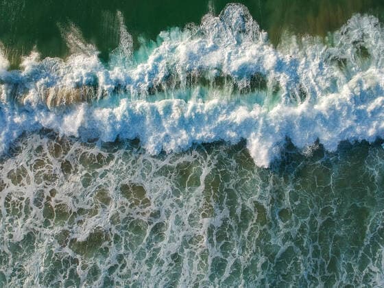 aerial view from a big wave crashing in a beach. Drone view Ericeira, Lisboa, Portugal CR_NUVA200901A-480241-01