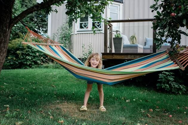 IMAGO Creative: Sommer, Sommertage im Garten young girl standing by a hammock smiling have fun in a garden at home Norrtälje, Stockholm County, Sweden CR_RABE200913-481211-01 ,model released, Symbolfoto