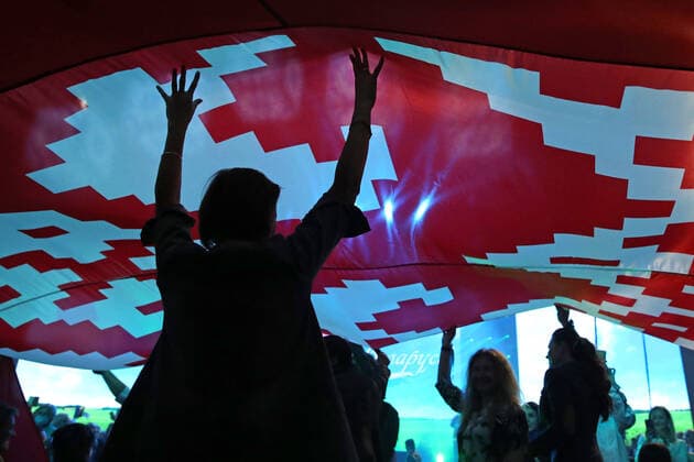 MINSK, BELARUS - SEPTEMBER 17, 2020: Members of the Belarusian Union of Women lift a Belarusian flag during a concert at Minsk Arena. Natalia Fedosenko TASS  TS0E74BF
