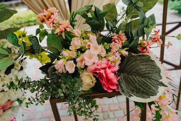 Beautiful wedding set up. Area of the wedding ceremony. Round arch, white chairs decorated with flowers, greenery. Cute, trendy rustic decor. Part of the festive decor, floral arrangement. Copyright: xx