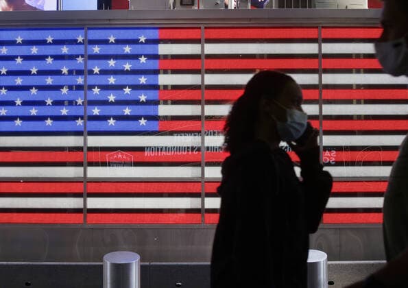 Pedestrians wear face masks while walking past an American Flag in Times Square in New York City on Tuesday, September 22, 2020. The number of U.S. coronavirus deaths reached 200,000 today.  NYP20200922108 JOHNxANGELILLO