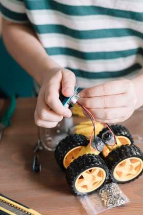 IMAGO Creative: NGO, Ausbildung für Kinder Close-up of boy making robotic toy on table at home model released Symbolfoto property released ALBF01533
