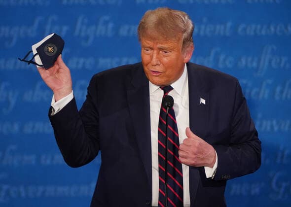 President Donald Trump holds up a face mask during the first of three scheduled 90 minute presidential debates with Democratic presidential nominee Joe Biden, in Cleveland, Ohio, on Tuesday, September 29, 2020.  CLE20200929537 KEVINxDIETSCH