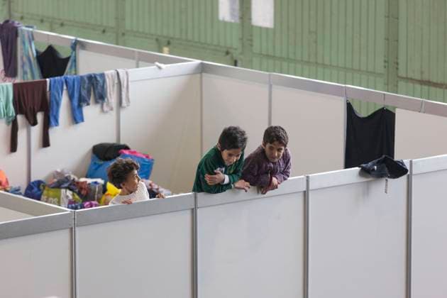 Notunterkunft fuer Fluechtlinge im ehemaligen Flughafen Tempelhof Kinder von Fluechtlinen schauen ueber die Wand eines provisorischen Zimmers in einer Notunterkuenft fuer Fluechtlinge am 09.12.2015 in ehemaligen Hangar des Flughafen Tempelhof. Der Flughafen Tempelhof dient der Stadt Berlin als Notunterkunft fuer Fluechtlinge. Berlin Berlin Deutschland *** Emergency shelter for refugees in the former Tempelhof airport Children of refugees look over the wall of a temporary room in an emergency shelter for refugees on 09 12 2015 in the former hangar of Tempelhof airport Tempelhof airport serves the city of Berlin as emergency shelter for refugees Berlin Berlin Deutschland