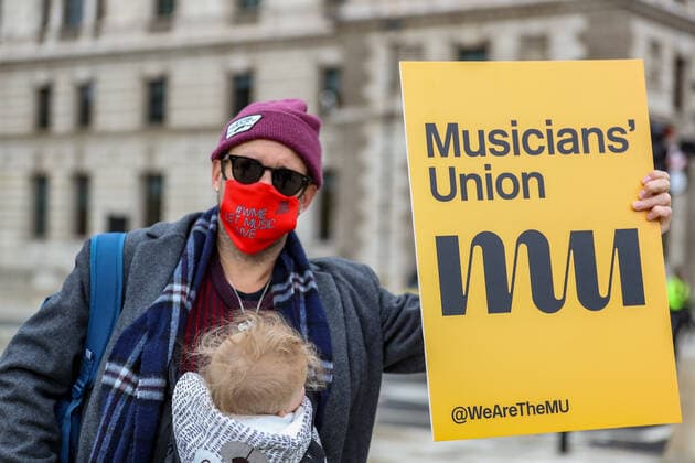 Musicians wearing face protective masks and holding placards are gathered in Parliament Gardens, outside the Houses of Commons in London, on Tuesday, Oct 6, 2020. Musicians in Britain are using their voices and instruments to protest against the government instructions to retrain and lack of support to the industry. , Let Music Live Protest London Parliament Gardens England United Kingdom  , Copyright: xVudixXhymshitix