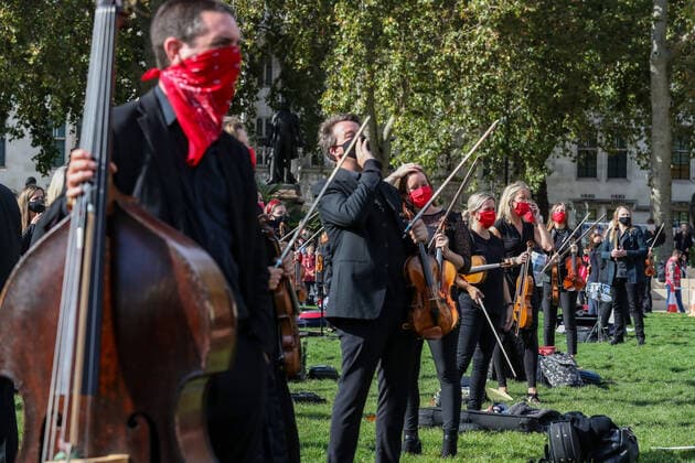 Freelance professional musicians wearing face protective masks and keeping social distance are gathered to perform a two-minute silence for the Let Music Live campaign, raising awareness of the need for targeted support for freelance musicians during the coronavirus pandemic and calling on the Government to recognise that freelance musician is an economic asset. The performance was concluded in Parliament Gardens, outside the Houses of Commons in London, on Tuesday, Oct 6, 2020. Musicians in Britain are using their voices and instruments to protest against the government instructions to retrain and lack of support to the industry. , Let Music Live Protest London Parliament Gardens England United Kingdom  , Copyright: xVudixXhymshitix