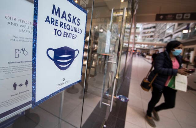 (201006) -- TORONTO, Oct. 6, 2020 -- A woman wearing a face mask walks past a store with a notice of mandatory mask requirement at CF Toronto Eaton Center in Toronto, Canada, on Oct. 6, 2020. Canada s daily cases of COVID-19 continued to increase. As of Tuesday afternoon, the country reported a total of 170,945 cases of COVID-19, including 9,527 deaths, according to CTV. (Photo by Xinhua) CANADA-TORONTO-COVID-19-CASES ZouxZheng