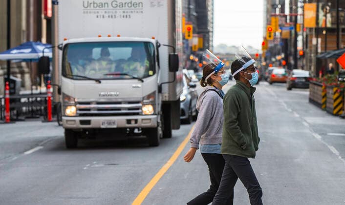 (201006) -- TORONTO, Oct. 6, 2020 -- People wearing face masks cross a street in Toronto, Canada, on Oct. 6, 2020. Canada s daily cases of COVID-19 continued to increase. As of Tuesday afternoon, the country reported a total of 170,945 cases of COVID-19, including 9,527 deaths, according to CTV. (Photo by Xinhua) CANADA-TORONTO-COVID-19-CASES ZouxZheng