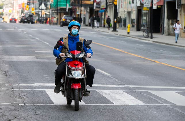 (201006) -- TORONTO, Oct. 6, 2020 -- A man wearing a face mask rides an electric bicycle in Toronto, Canada, on Oct. 6, 2020. Canada s daily cases of COVID-19 continued to increase. As of Tuesday afternoon, the country reported a total of 170,945 cases of COVID-19, including 9,527 deaths, according to CTV. (Photo by Xinhua) CANADA-TORONTO-COVID-19-CASES ZouxZheng