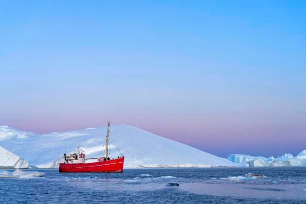  Rotes Boot mit Touristen vor Eisbergen zur blauen Stunde, Eisfjord, UNESCO-Weltnaturerbe, Diskobucht, Ilulissat, Westgrönland, Grönland, Nordamerika *** Red boat with tourists in front of icebergs at the blue hour, Icefjord, UNESCO World Heritage, Disko Bay, Ilulissat, West Greenland, Greenland, North America Copyright: imageBROKER/StefanxHuwiler iblshu05843806.jpg