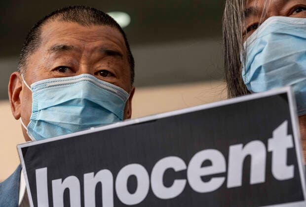 October 15, 2020, Hong Kong, China: Media tycoon Jimmy Lai (L) and Leung Kwok-hung (R), also known as Long Hair, holds a placard with the message Innocent to mourn is seen at the West Kowloon court ahead of their trial in court..Media tycoon Jimmy Lai and other pro-democracy activists including Joshua Wong appear in court for charges of participating and organizing an illegal anti government Tiananmen Square Vigil assembly in June 2019. Hong Kong China - ZUMAs197 20201015_zaa_s197_035 Copyright: xMiguelxCandelax
