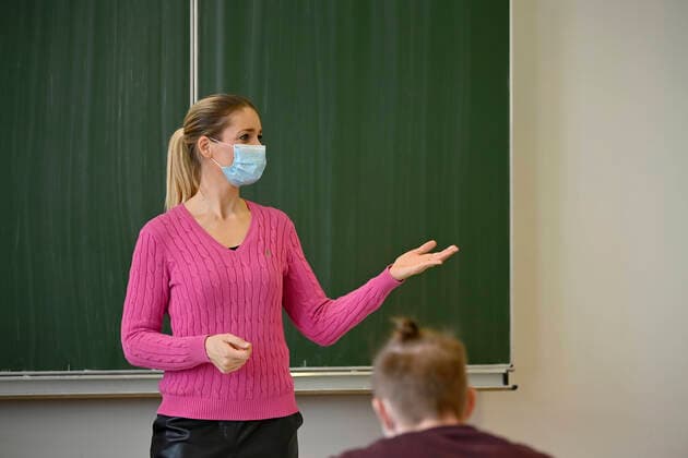 Teacher with face mask in classroom teaching, Corona crisis, Stuttgart, Baden Württemberg, Germany Coronavirus
