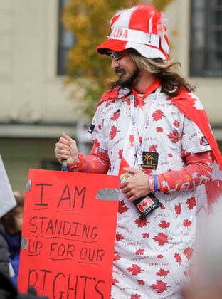 (201017) -- VANCOUVER, Oct. 17, 2020 -- A protester holds a sign as he takes part in an anti-restriction rally in Vancouver, British Columbia, Canada, on Oct. 17, 2020. Thousands of protesters took part in the anti-coronavirus-restriction rally to express their disapproval over a number of topics including lockdowns, mask mandates, quarantine, travel bans and social distancing. (Photo by Xinhua) CANADA-VANCOUVER-COVID-19-ANTI-RESTRICTION PROTEST LiangxSen 