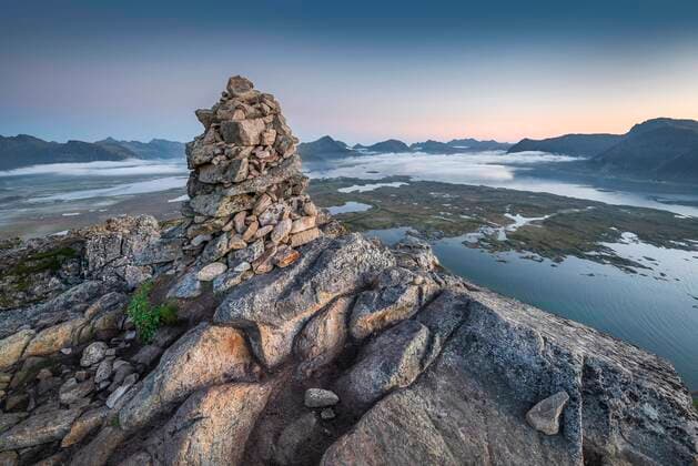 Stone pyramid at the top of Hoven at dusk, mountains on the horizon and fjords with clouds, Gimsøy, Lofoten, Nordland, Norway, Europe Copyright: imageBROKER/GerhardxZwerger-Schoner ibxgzs05886335.jpg