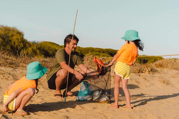 IMAGO Creative: Neue Aussichten Father and daughters cleaning garbage at beach model released Symbolfoto ERRF04467