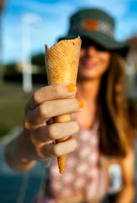 IMAGO Creative, Jahreszeit Sommer, Sommer in der Stadt IMAGO Creative: 2021 Favoriten Young woman showing ice cream cone while spending leisure in city during weekend model released Symbolfoto MGOF04495
