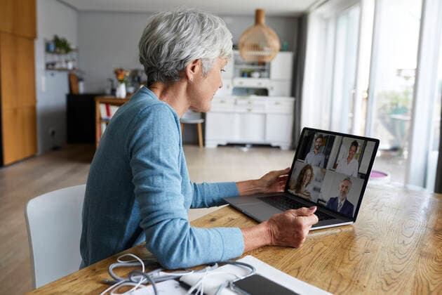 Active senior woman attending meeting on video conference while sitting at home model released Symbolfoto property released RBF07869