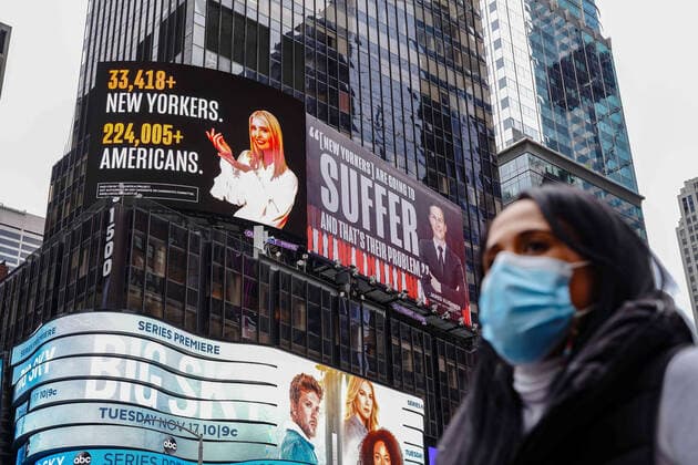 October 25, 2020, New York, United States: A woman wearing a face mask walks past a Lincoln Project Billboard that depicts Ivanka trump presenting the number of New Yorkers and americans who have died of Covid-19 and Jared Kushner next to a Vanity Fair quote. New York United States - ZUMAs197 20201025_zaa_s197_193 Copyright: xJohnxNacionx