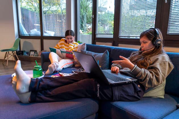 Homeschooling, 2 girls, sisters, 11 years old, learning at home, home learning, lessons at home, distance learning, chat with teachers and classmates via laptop, tablet PC, symbol image, homeschooling