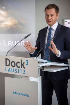 Sachsens Ministerpräsident Michael Kretschmer DEU Sachsen Schwarze Pumpe Â Zur Eröffnung des neuen Kompetenz- und Gründerzentrum Dock3 in Schwarze Pumpe sprach auch Sachsens Ministerpräsident Michael Kretschmer. Das Kompetenzzentrum für Gründer & Gewerbe liegt auf der Landesgrenze von Sachsen und Brandenburg und wude im Auftraggeber des Zweckverbandes Industriepark Schwarze Pumpe eröffnet.. Das Kompetenzzentrum DockÂ³ soll Startups und Unternehmen ideale Bedingungen bieten, um neue Ideen, innovative Geschäftsfelder sowie zukunftsträchtige Produkte und Technologien zu entwickeln und umzusetzen. Voll ausgestattete Büro- und Tagungsräume, Coworking-Plätze sowie flexibel gestaltbare Fertigungsflächen in einer separaten Werkha