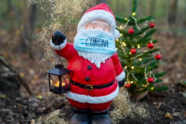 Symbolic photo, Santa Claus with Corona mouth nose protection Symbolic image Santa Claus with mask The Advent season and Christmas seem to take place this year under strong Corona and possible contact restrictions Here a Santa Claus with Corona face mask and Christmas tree in the forest Germany