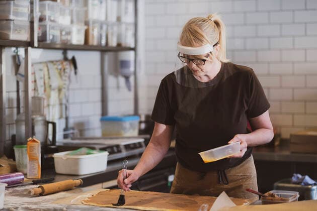 Blond waitress wearing face mask working in a cafe, preparing food. Cafe,United Kingdom,Blond waitress wearing face mask working in a cafe, preparing food.  Blond waitress wearing face mask working in a cafe, preparing food.