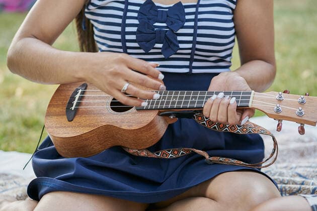 Close-up of a woman playing ukelele with a group of friends Elcarte, Navarra, Spain CR_SEBO201027B-529228-01 ,model released, Symbolfoto