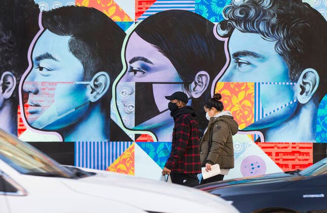 (201120) -- TORONTO, Nov. 20, 2020 -- People wearing face masks walk past a mural in Toronto, Canada, on Nov. 20, 2020. Canadian Prime Minister Justin Trudeau said on Friday that the country is at stake as COVID-19 has been worsening. As of Friday afternoon, Canada reported a total of 319,038 cases and 11,313 deaths. (Photo by Xinhua) CANADA-TORONTO-COVID-19-CASES ZouxZheng 