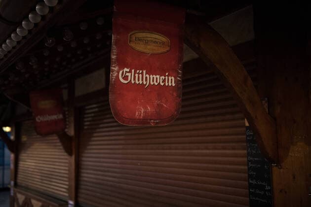 A sign with the inscription Glühwein hangs at a closed sales stand on the Christmas market at Potsdamer Platz in Berlin Photo picture christmas market in lockdown