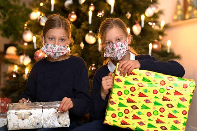 24 11 2020, Modelreleased symbol picture, A family in Allgäu sits in front of the Christmas tree in the living room on Christmas Eve, Two siblings with mouth-noses Protective mask wai