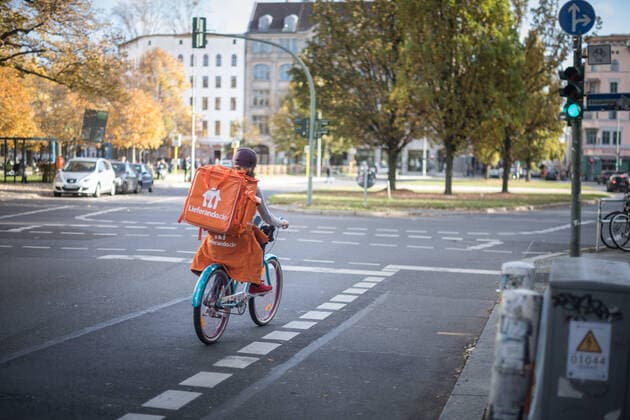 Ein Fahrradkurier der Firma Lieferando faehrt in Berlin Kreuzberg auf einer Kreuzung. Foto: bildgehege Bringedienst Lieferando *** A bicycle courier of the company Lieferando drives in Berlin Kreuzberg on a crossing photo bildgehege Bringing service Lieferando