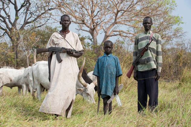 South Sudan, Dinka tribe SOUTH SUDAN, Lakes State, Cueibet , Gok Dinka tribe protect their Zebu cow cattle herds with Kalashnikov AK-47 rifle against hostile cattle raider *** SÜDSUDAN, Lakes State, Cuibet, Dinka Hirten schuetzen ihre Herden mit Zeburindern vor Viehdiebstaehlen von feindlichen Clans mit einem Kalaschnikow AK 47 Maschinengewehr, links Hirte Matur 18 Jahre und sein Bruder Makuei 11 Jahre Cuibet Lakes South Sudan