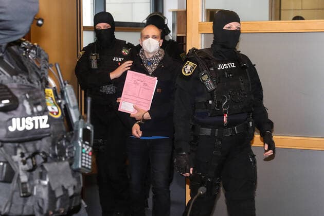 Der Angeklagte wird mit Mundschutz in den Verhandlungssaal gebracht - Prozesstag zweiundzwanzig im Landgericht Magdeburg gegen den Halle Attentäter Stephan Balliet, insgesamt fünf Richterinnen und Richter entscheiden am Ende über das Urteil, ein sechster steht als Reserve parat. Die Vorsitzende Richterin ist Ursula Mertens. 43 Nebenklägerinnen und -kläger sind zum Prozess am Landgericht in Magdeburg zugelassen, die von 21 Anwälten beraten werden. Personen Bitte Pixeln-Personen Unkenntlich machen *** The defendant is brought into the hearing room with a mouth guard Day of trial twenty-two in the Magdeburg Regional Court against the hall assassin Stephan Balliet, a total of five judges decide on the verdict in the end, a sixth is standing by