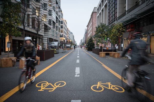 Cyclists in both directions on the cycle path in Friedrichstrasse in Berlin Mitte Photo picture enclosure cycle path Friedrichstrasse