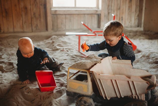 IMAGO Kreativ: Bruderschaft Brothers playing with trucks and shovels in outdoor sandbox in winter Kempten, BY, Germany CR_TANI201208B-573623-01 ,model released, Symbolfoto