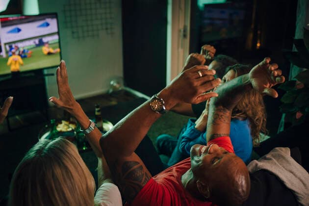 High angle view of friends cheering while watching sports on TV in living room, MA82799, Sweden, Stockholm, model released, property released Copyright: xMaskotx