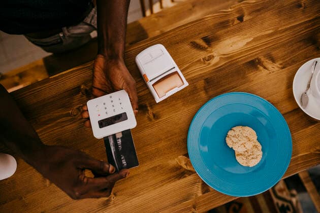 High angle view of cafe owner using credit card reader over kitchen counter at coffee shop, MA82938, Germany, Berlin, model released, property released Copyright: xMaskotx
