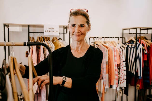 Portrait of smiling senior owner arranging clothes in store, MA82952, Germany, Berlin, model released, property released Copyright: xMaskotx