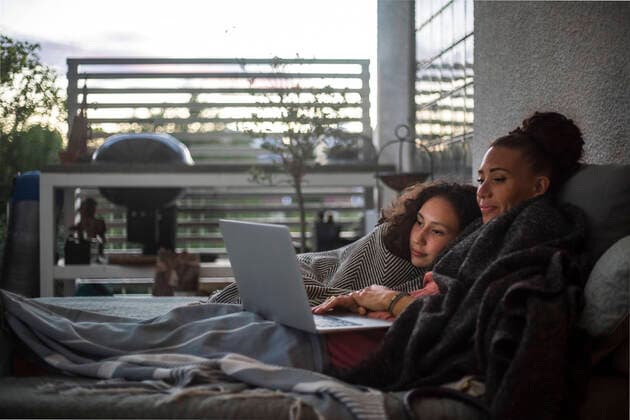 Mother and daughter watching laptop while relaxing on sofa at home, MA83018, Sweden, Stockholm, model released, property released Copyright: xMaskotx