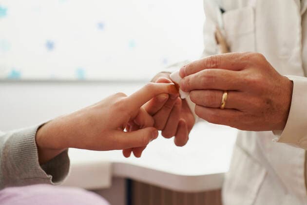 Close-up of a female doctor placing a band-aid on a girl s finger on her bed. Home doctor concept Pamplona, Navarre, Spain CR_SEBO201210E-575499-01 ,model released, Symbolfoto