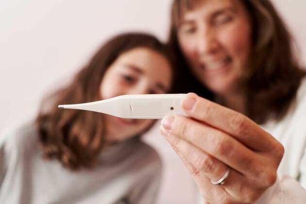 Female doctor teaching the temperature on a thermometer to a girl in her bed. Home doctor concept Pamplona, Navarre, Spain CR_SEBO201210E-575527-01 ,model released, Symbolfoto