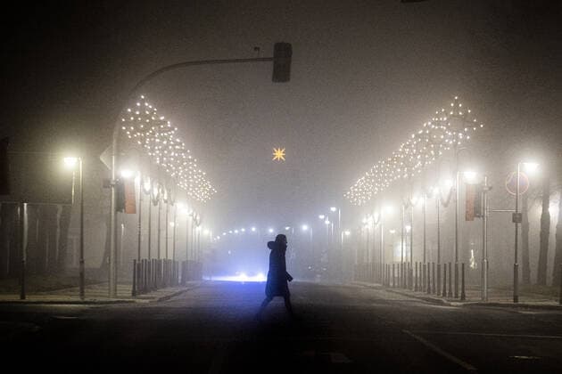 A woman walks along a street decorated with Christmas lights in the fog in Niesky, 11 12 2020 The government of Saxony has announced a lockdown from Monday, 14 12 to reduce the infection rate of the Corona pandemic before Christmas. Copyright: xFlorianxGaertner photothek.dex