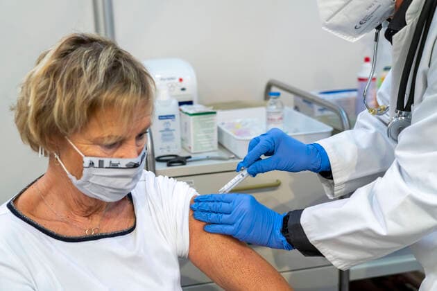 Vaccinator makes a vaccination, during the test run in the vaccination centre for corona vaccinations, in a hall at Messe Essen, through the city, the fire brigade and various aid organisations, 12 vaccination routes for a daily vaccination of up to 2400 people, operated by the Kassenärztliche Vereinigung NRW, Impfzentrum
