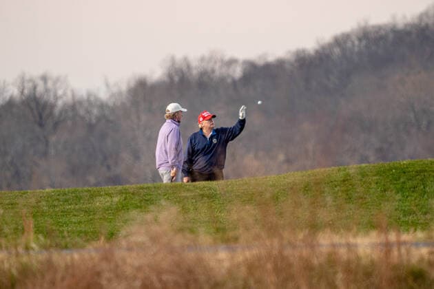 United States President Donald J. Trump reaches out to catch a golf ball tossed to him as he plays golf at Trump National Golf Club in Sterling, Virginia on Sunday, December 13, 2020.  WAP20201213501 KenxCedeno