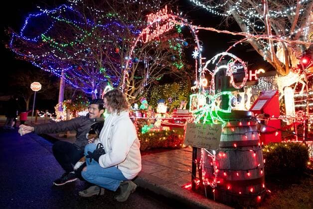 (201215) -- RICHMOND, Dec. 15, 2020 -- People take photos in front of lights on display at the Ho Ho Ho house of the Woodman family in Richmond, Canada, Dec. 14, 2020. The Woodman family in Richmond has decorated their house, also known as the Ho Ho Ho house, for more than 30 years during the Christmas festive season. (Photo by Xinhua) CANADA-RICHMOND-CHRISTMAS-LIGHTS DISPLAY AndrewxSoong 